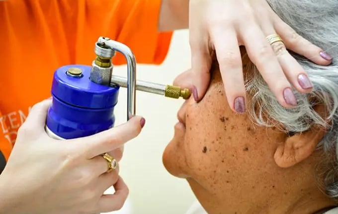 a woman is getting her hair brushed off by a hair dryer