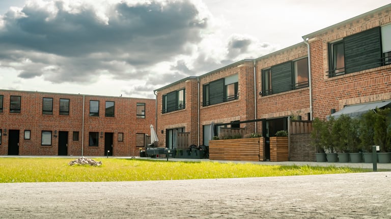 Innenhof mit modernen Reihenhäusern aus rotem Klinker und kleinen Terrassenbereichen 