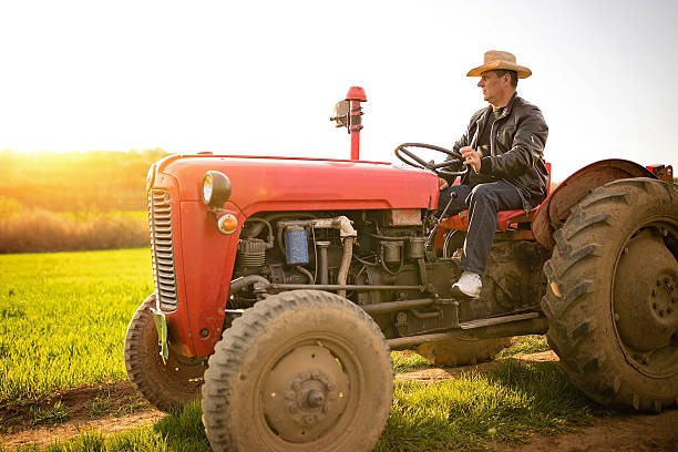 a man in a cowboy hat sitting on a tractor