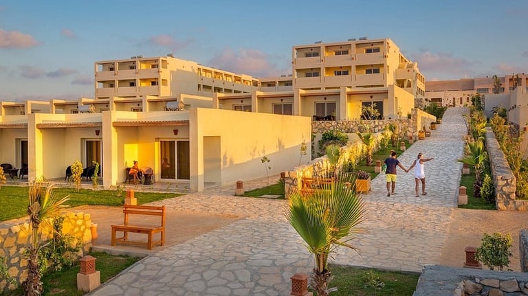 a couple of people walking down a path in front of a building | Nour Nagy Designs