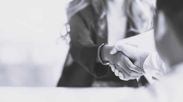 a woman shaking someone's hand over a table