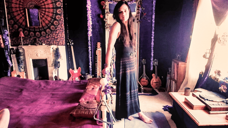 a woman standing in front of a mirror in a bedroom