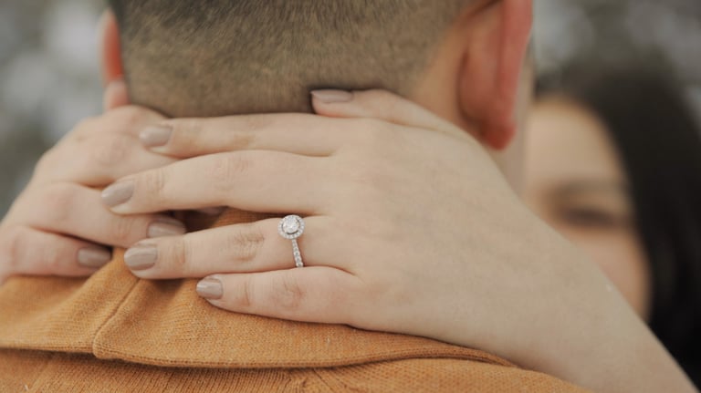 a man and woman holding hands and wearing rings