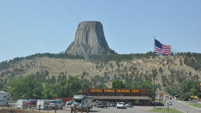 a mountain view of devils tower with a flag flying in the air
