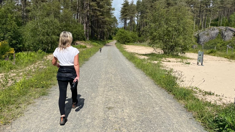 Tracey Billington walking through Newborough nature reserve forest