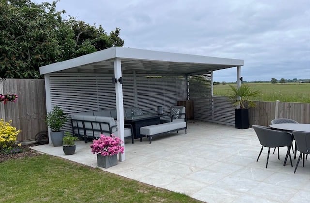 A modern porcelain slab patio area and pergola with roof