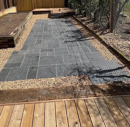 Reclaimed sleeper beds. Slate slab patio and golden gravel