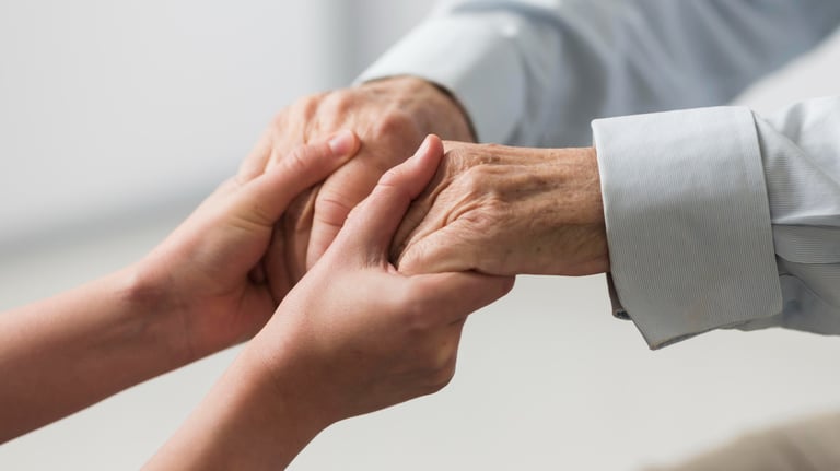 aidant tenant les mains d'un senior aidé alzheimer