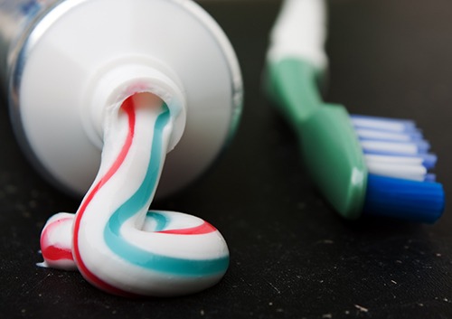 a image showing toothpaste squeezed from tube and a toothbrush