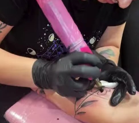 a woman getting a tattoo on her arm by a female tattoo artist that is creative and talented in craft