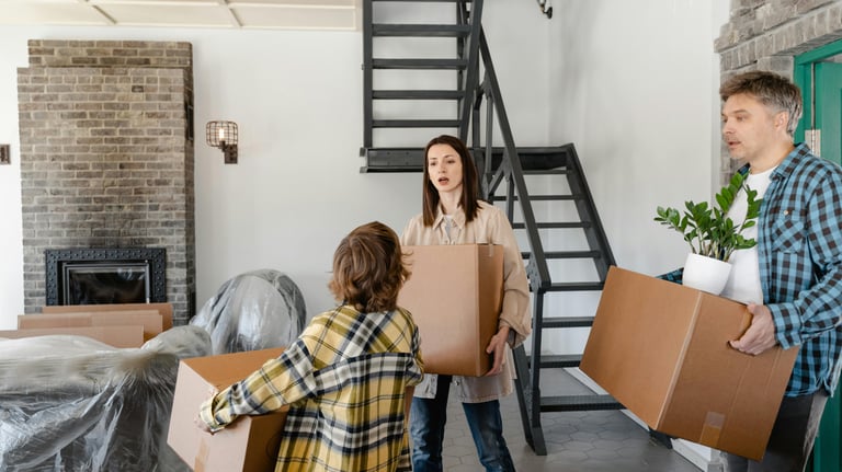 a military family moving boxes in a house during their PCS Move