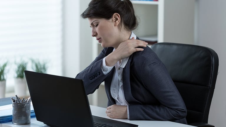 Trabajadora con dolor de espalda por accidente laboral en oficina solicitando ayuda