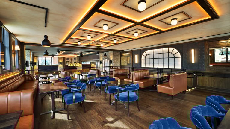 Modern restaurant interior with blue chairs and geometric lighting.