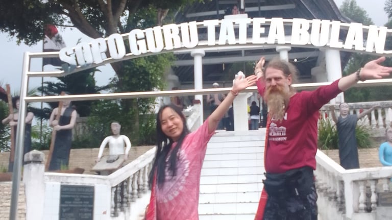 a woman and a man are joyful and smiling in front of an ancient shrine site in Sumatra