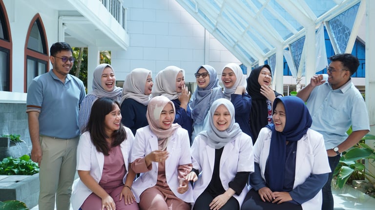 Tim tenaga kesehatan tertawa bersama dalam suasana santai di luar ruangan