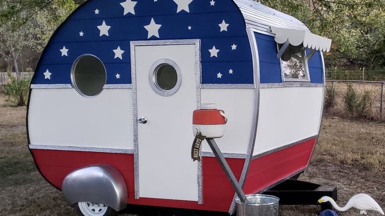 Red, white and blue American Flag Themed Custom Painted Camper complete with falling white stars