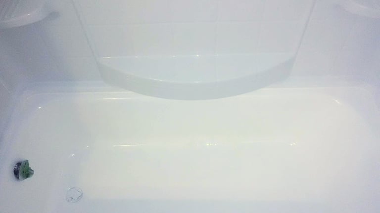 White glossy bathtub freshly refinished making it appear nearly new again