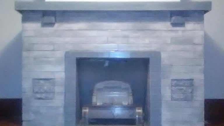 Light gray and gray-blue custom painted and partially stained brick fireplace and mantle