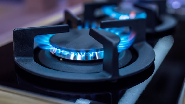 a gas stove top with blue flames on a stove top