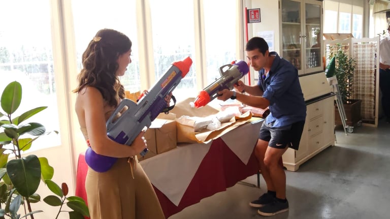 a man and woman are playing with a toy gun