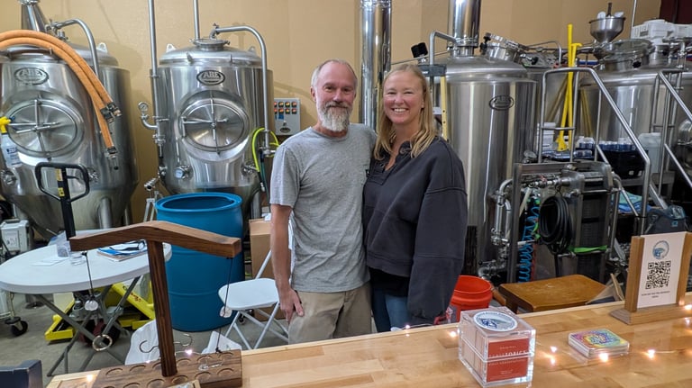 michael and kathleen cherry standing in front of brewing tanks