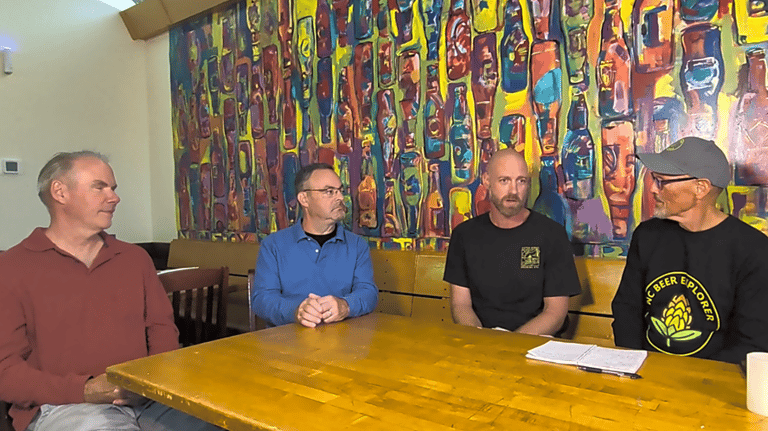 four men seated at a table at OBX Brewing Station