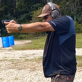 Man using self-defense firearm on range.