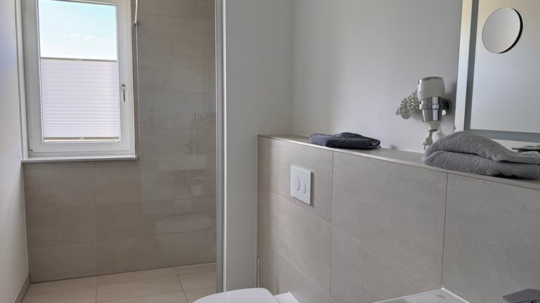 Zeitloses Badezimmer mit Blick in die ebenerdige Dusche