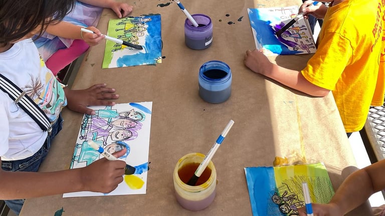 children applying watercolor wash to a drawing