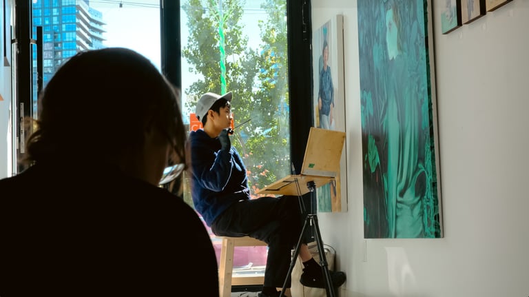 a man sitting on a chair in front of a painting
