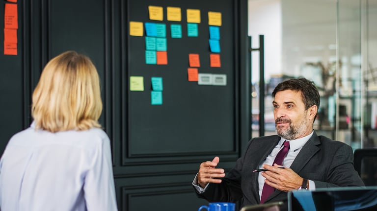 a man and woman sitting at a table with papers and papers