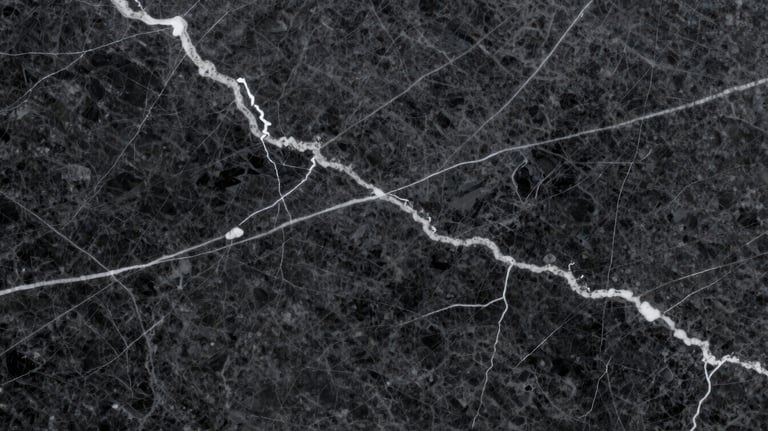 Close-up shot of a dark charcoal marble slab with striking white lightning-style veins, highlighting the premium quality and depth of the stone.