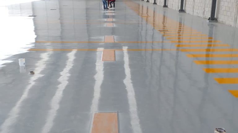 piso epóxico industrial con señalización de seguridad en nave de producción