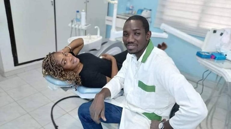 Dentiste professionnel en uniforme blanc posant avec une patiente souriante.