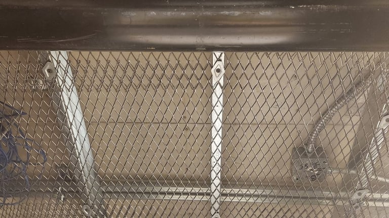 Secure ceiling installation using heavy-duty wire mesh above a suspended ceiling to prevent access t