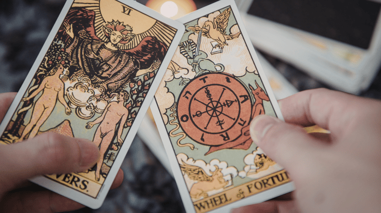 mãos segurando 2 cartas de tarot
