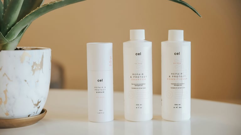 Cel Re:Gen Repair & Protect hair care products, including serum, shampoo, and conditioner, displayed with a potted aloe vera