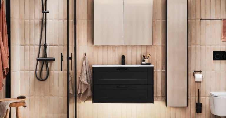 Modern bathroom with black floating vanity, walk-in shower, and vertical beige tiles.