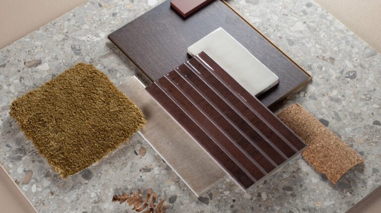 Interior design mood board featuring terrazzo tile, dark wood flooring, and olive green carpet samples.