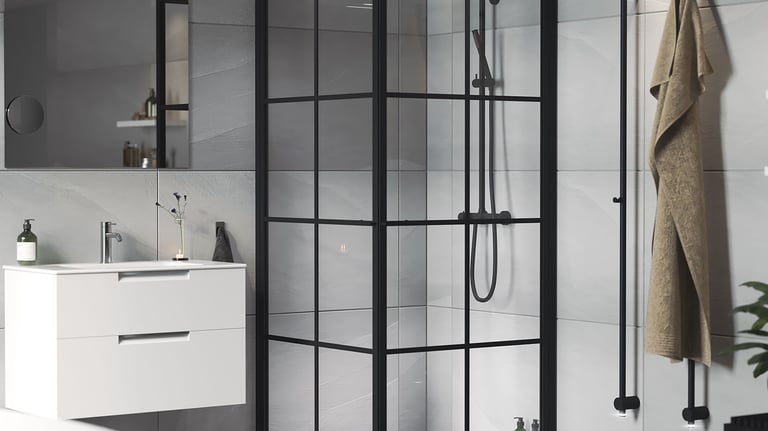 Modern bathroom featuring a black framed glass shower enclosure and a white floating vanity.