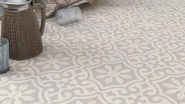 Elegant grey and white patterned ceramic floor tiles with a vintage fleur-de-lis inspired design.