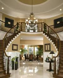 Majestueux hall d'entrée élégant, doté d'un double escalier courbe et d'un luxueux lustre à kribi