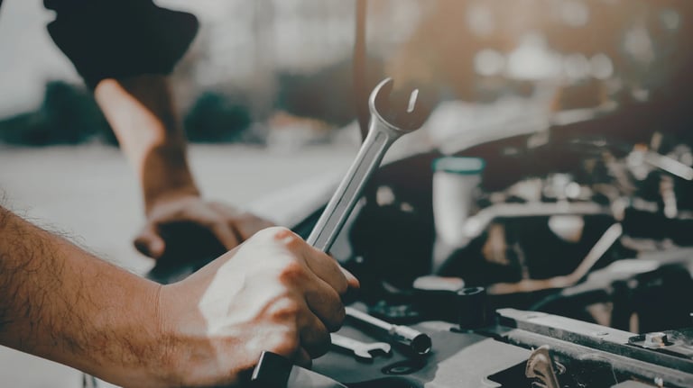 Mechanic repairing a car engine with a wrench