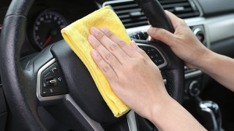 Technician carefully cleaning a car interior with specialized tools