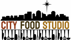City Food Studio logo with bold orange and yellow text on a black background for a commercial kitchen.