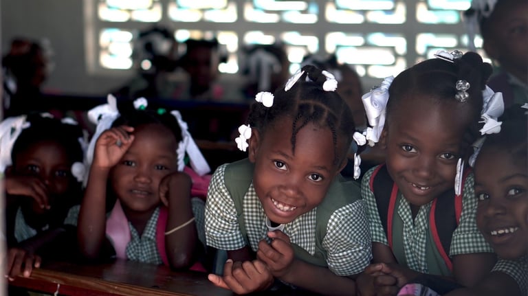 a group of children in school uniforms smiling and posing for a picture