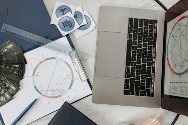 a laptop computer sitting on a desk calculating birth charts
