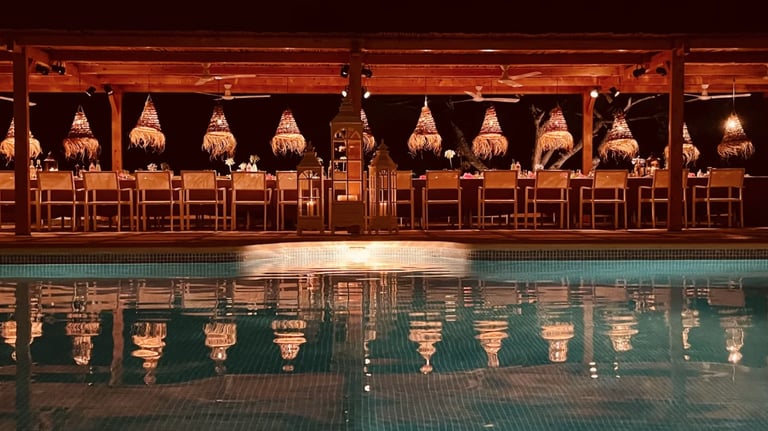 Poolside themed dinner under illuminated wooden pergola