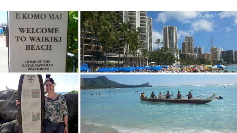 Autora na praia de Waikiki com vista da cidade de Honolulu e barco tradicional no mar