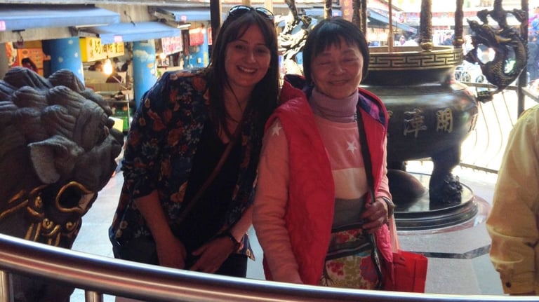 Autora posando com uma senhora local no templo Qingan, em Keelung.